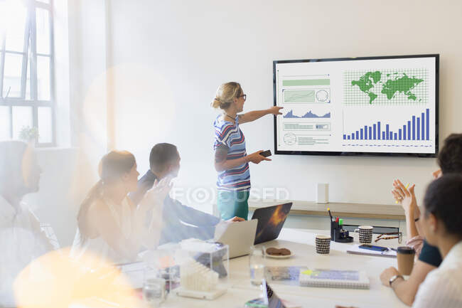 Unternehmerin am Fernsehbildschirm leitet Konferenz im Konferenzraum — Stockfoto
