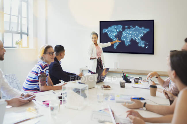 Female designer at television screen leading conference room meeting — Stock Photo
