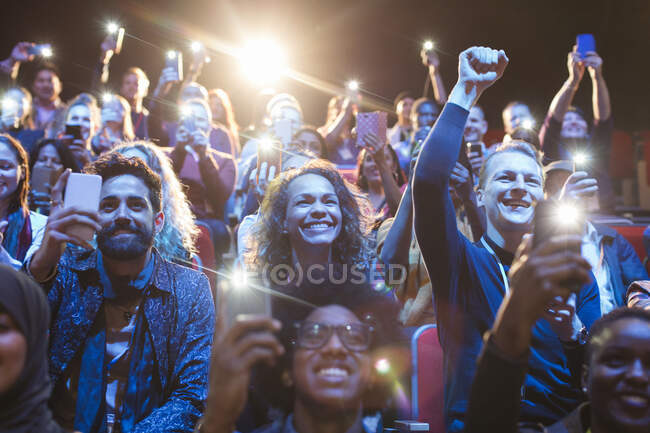 Público animado com lanternas de telefone inteligente torcendo — Fotografia de Stock