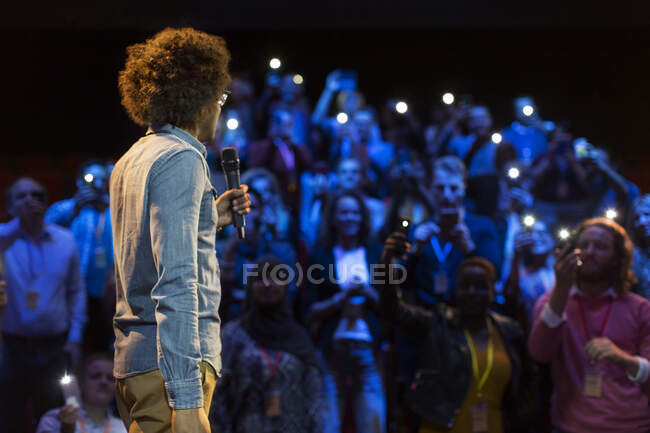 Público com lanternas inteligentes ouvindo alto-falante com microfone — Fotografia de Stock