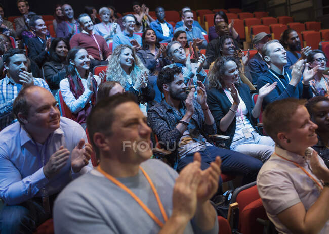 Audiencia aplaudiendo, disfrutando de la conferencia - foto de stock