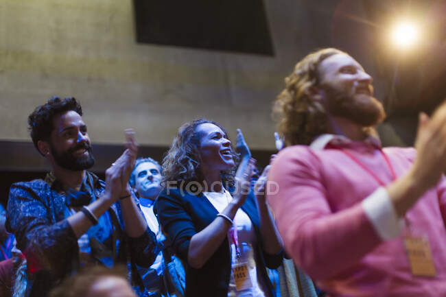 Excited audience clapping in dark room — Stock Photo