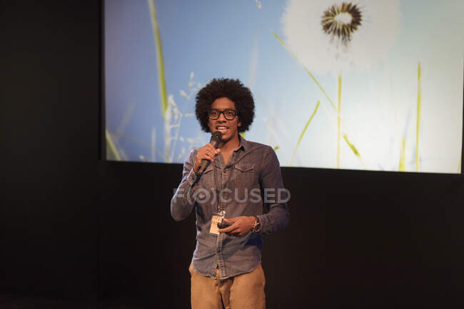 Retrato altifalante masculino com microfone falando no palco — Fotografia de Stock