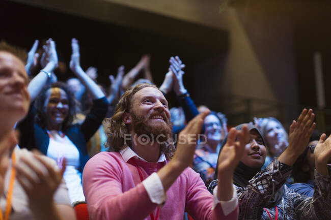 Smiling, enthusiastic man clapping in audience — Stock Photo