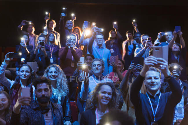 Eifriges Publikum mit Smartphone-Taschenlampen im dunklen Zuschauerraum — Stockfoto