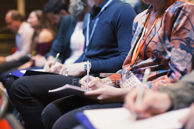 Business people taking notes in conference audience — Stock Photo