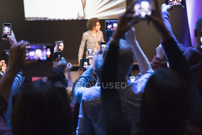 Аудиторія з камерними телефонами, що фотографують динамік на сцені — стокове фото