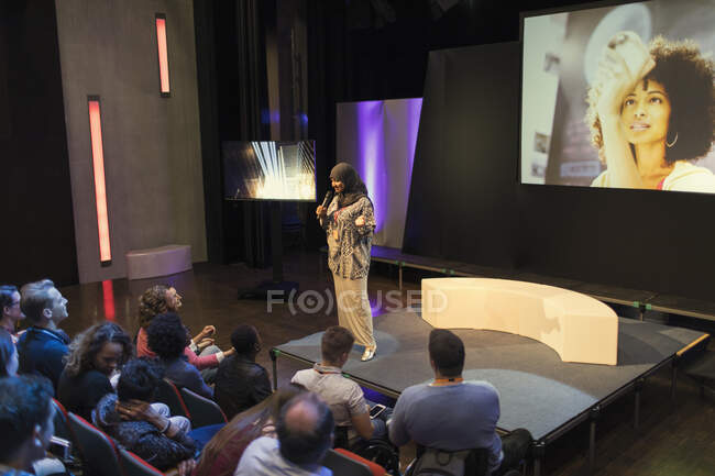 Female speaker in hijab on stage talking to audience — Stock Photo