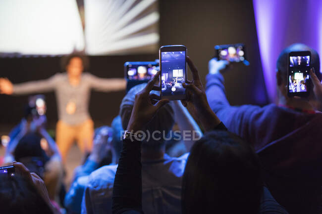 Público con teléfonos de cámara fotografiando altavoz en el escenario - foto de stock