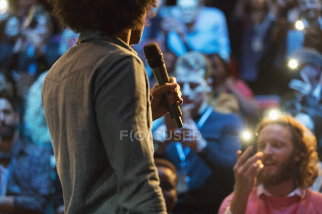 Speaker with microphone talking to audience — Stock Photo