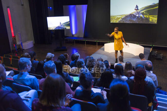 Oradora en el escenario respondiendo preguntas del público - foto de stock