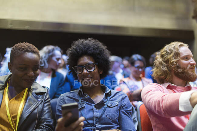 Деловые люди используют смартфон в аудитории конференции — стоковое фото