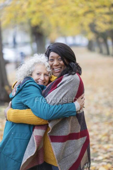 Entusiastas amigas mayores abrazándose en el parque de otoño - foto de stock