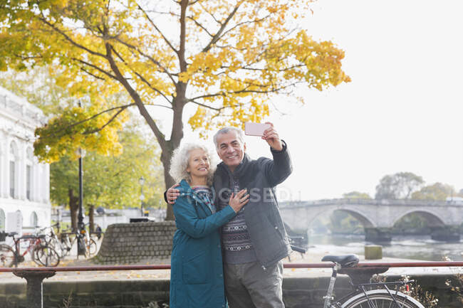Couple aîné prenant selfie en face de l'arbre d'automne — Photo de stock