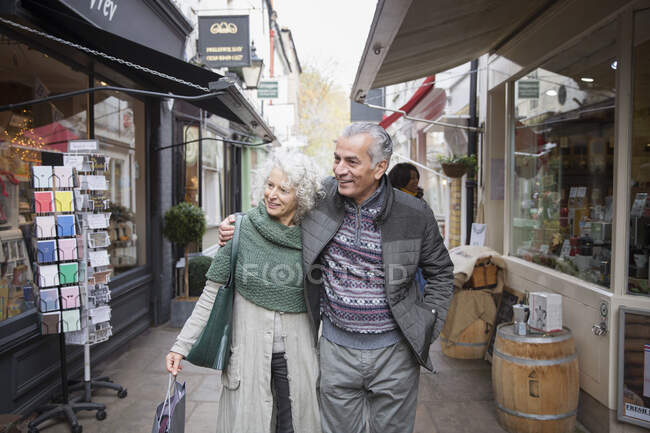 Senioren-Paar geht in Gasse einkaufen — Stockfoto