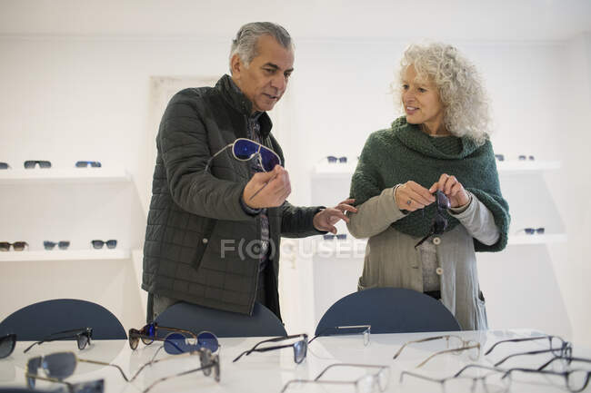 Seniorenpaar kauft Brille und Sonnenbrille im Optometriegeschäft — Stockfoto