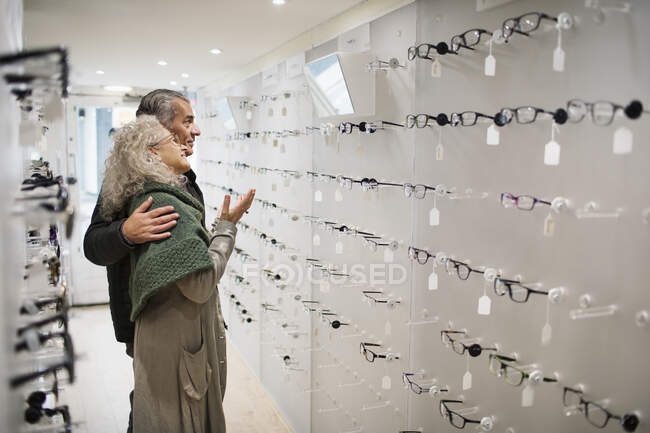 Coppia di anziani shopping per occhiali in negozio di optometria — Foto stock