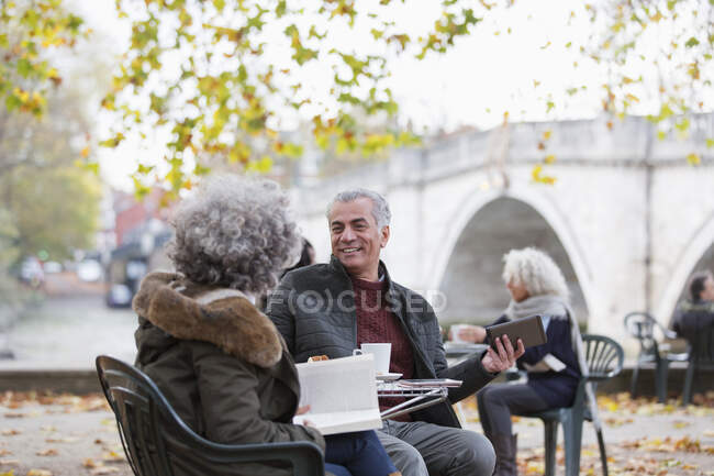 Активная пожилая пара в осеннем кафе на тротуаре — стоковое фото