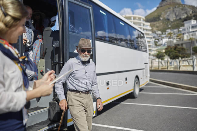 Aktive Seniorin steigt aus Tourbus aus — Stockfoto