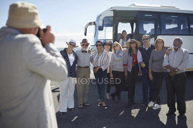 Amigos turísticos seniores ativos posando para fotografia fora do ônibus turístico — Fotografia de Stock