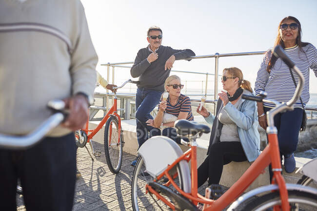 Amis aînés actifs touristes avec des vélos manger de la crème glacée — Photo de stock