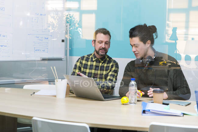 Empresarios usando laptop en reunión de sala de conferencias - foto de stock