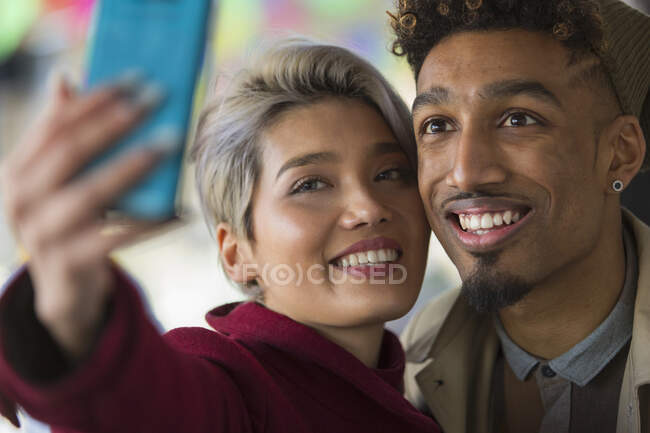 Улыбающаяся молодая пара делает селфи с камерой телефона — стоковое фото