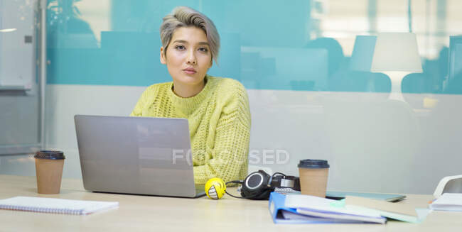 Портрет уверенной, целеустремленной молодой предпринимательницы, работающей за ноутбуком — стоковое фото