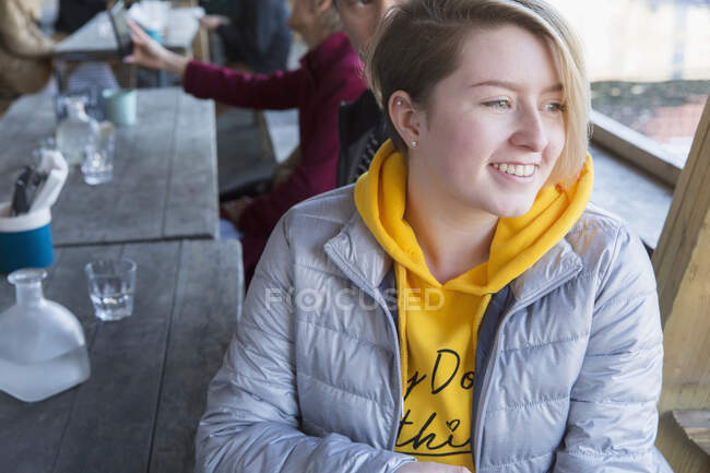 Lächelnde junge Frau speist auf der Außenterrasse des Restaurants — Stockfoto