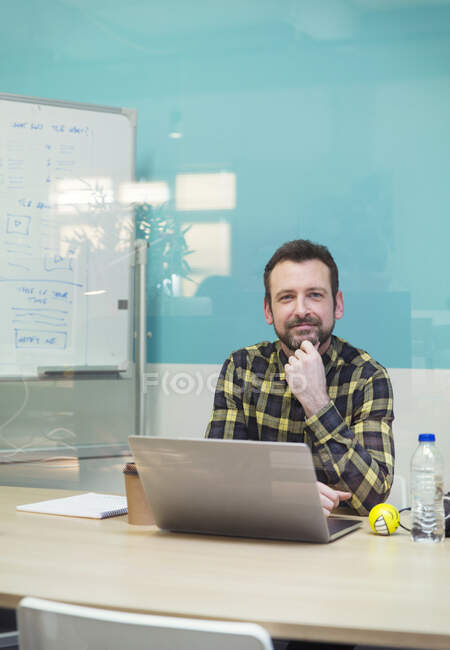 Портрет уверенный бизнесмен, работающий за ноутбуком в конференц-зале — стоковое фото