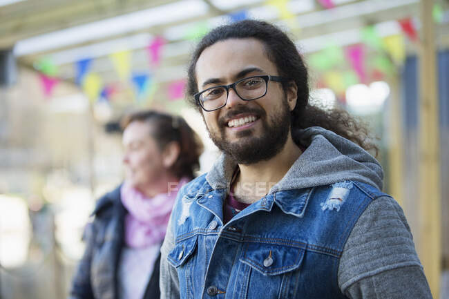 Portrait jeune homme souriant avec barbe et cheveux longs — Photo de stock