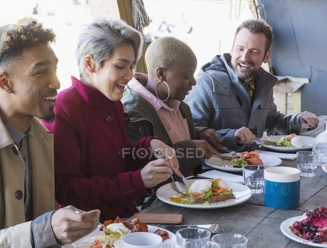 Amigos desayunando en el restaurante patio al aire libre - foto de stock