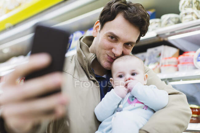 Zärtlicher Vater und kleine Tochter machen Selfie im Supermarkt — Stockfoto