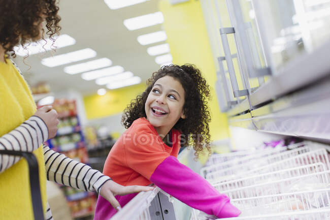 Mãe e filha comprando alimentos congelados no supermercado — Fotografia de Stock
