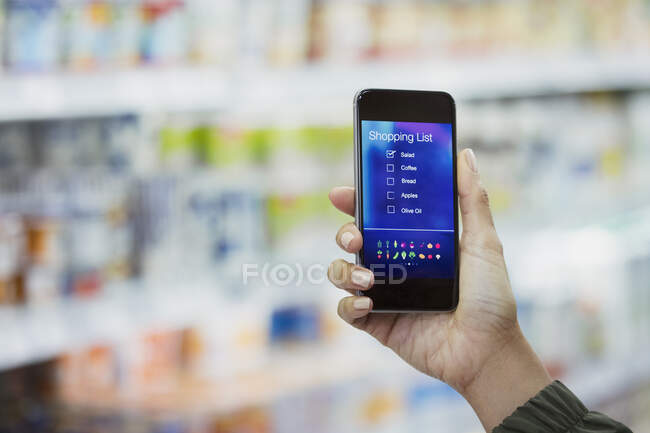 Perspectiva pessoal mulher verificando lista de compras digitais no telefone inteligente no supermercado — Fotografia de Stock