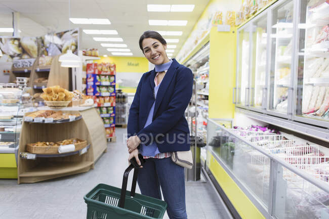 Retrato sonriente mujer de compras en el supermercado - foto de stock