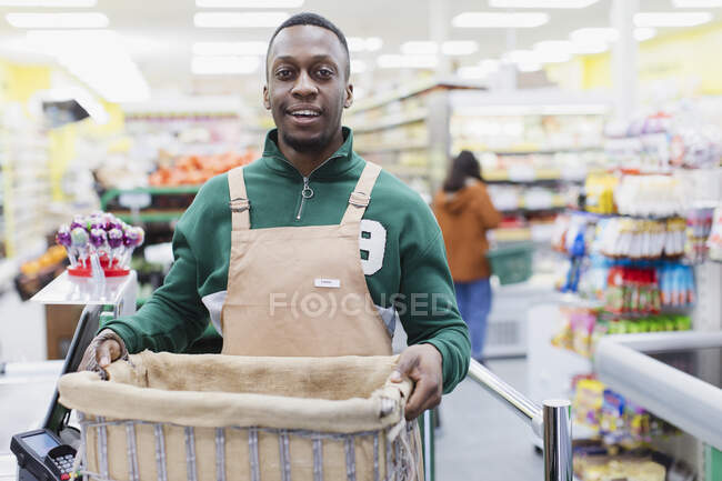 Ritratto fiducioso droghiere maschile che lavora nel supermercato — Foto stock