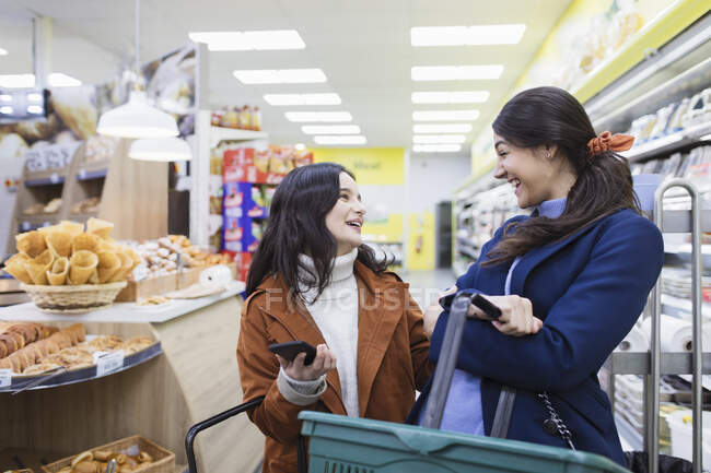Happy women friends shopping in supermarket — Stock Photo