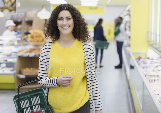 Портрет усміхнений, впевнена жінка купує в супермаркеті — стокове фото