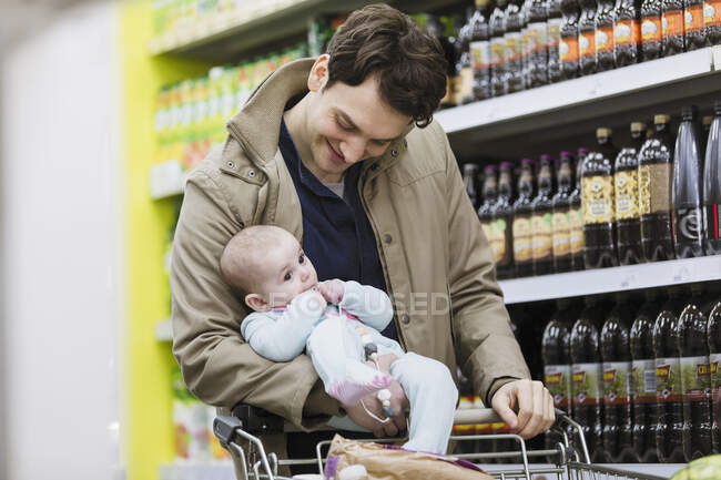 Батько з дитячою дочкою купує в супермаркеті — стокове фото