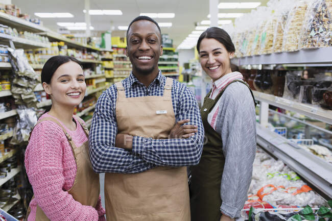 Portrait confident, smiling grocers working in supermarket — Stock Photo