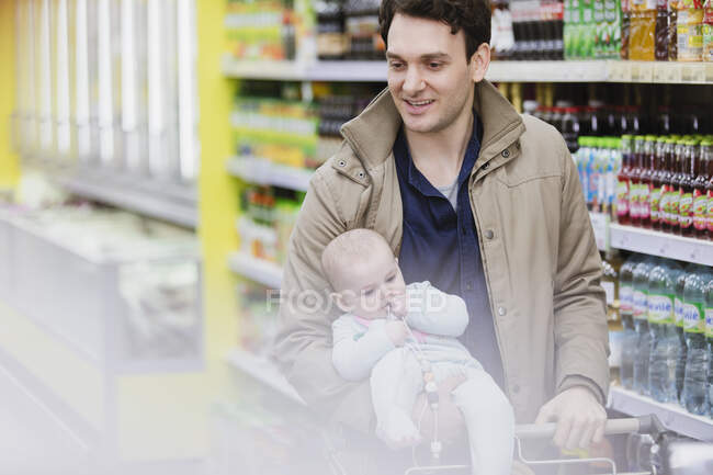 Father and baby daughter shopping in supermarket — Stock Photo