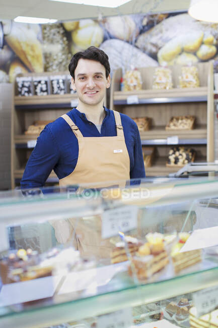 Портрет впевнений чоловік працює на виставці хлібобулочних виробів у супермаркеті — стокове фото