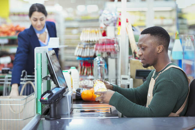 Caixa ligando para o cliente no checkout do supermercado — Fotografia de Stock