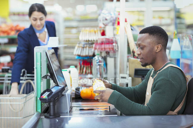 Cajero llamando al cliente en la caja del supermercado - foto de stock