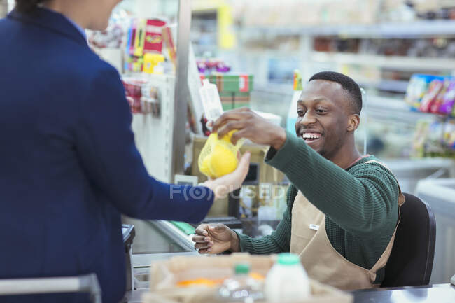 Cajero ayudando al cliente en la compra del supermercado - foto de stock