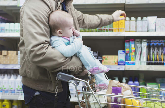 Father with baby shopping in supermarket — Stock Photo