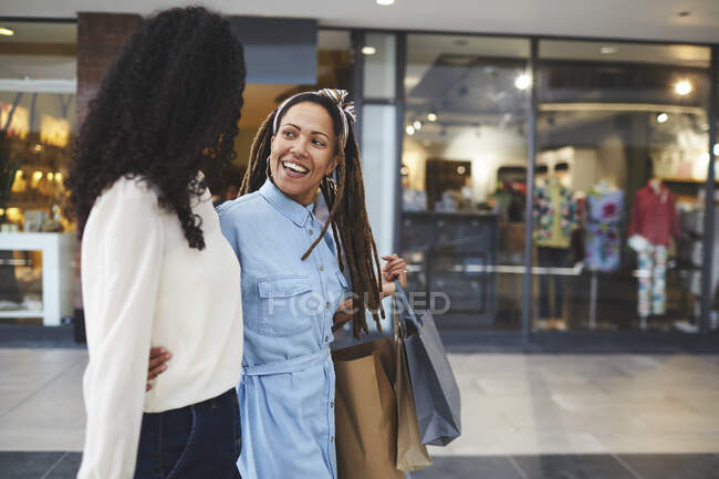 Lächelnde Freundinnen beim Einkaufen in Einkaufszentrum — Stockfoto