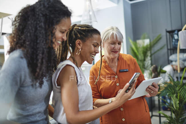 Woman helping customers in home decor shop — Stock Photo