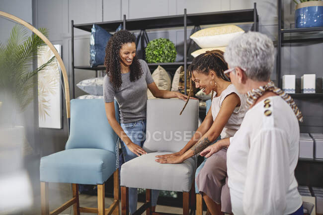 Mulheres que compram cadeiras de jantar na loja de decoração de casa — Fotografia de Stock